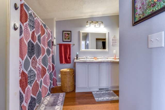 bathroom with hardwood / wood-style floors, vanity, crown molding, a textured ceiling, and a shower with shower curtain