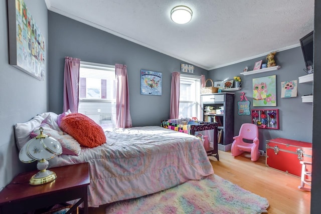 bedroom with crown molding, a textured ceiling, multiple windows, and hardwood / wood-style flooring