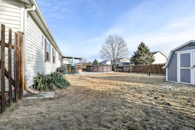 view of yard featuring a shed and a fenced in pool