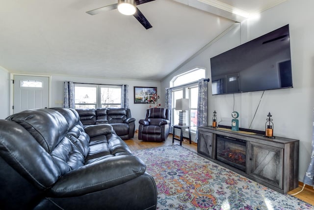 living room featuring lofted ceiling, light hardwood / wood-style flooring, ornamental molding, and ceiling fan