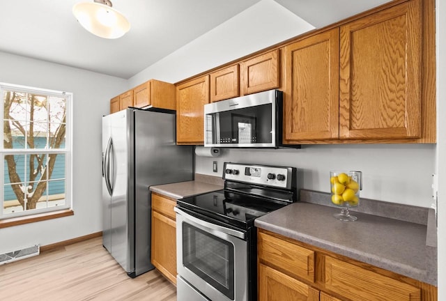 kitchen featuring stainless steel appliances and light hardwood / wood-style flooring