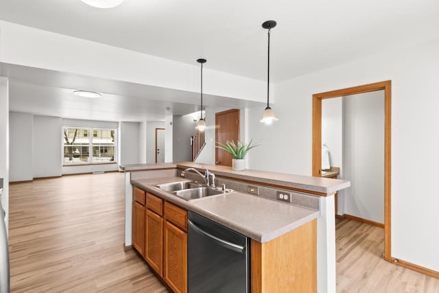 kitchen with sink, decorative light fixtures, light wood-type flooring, stainless steel dishwasher, and a kitchen island with sink