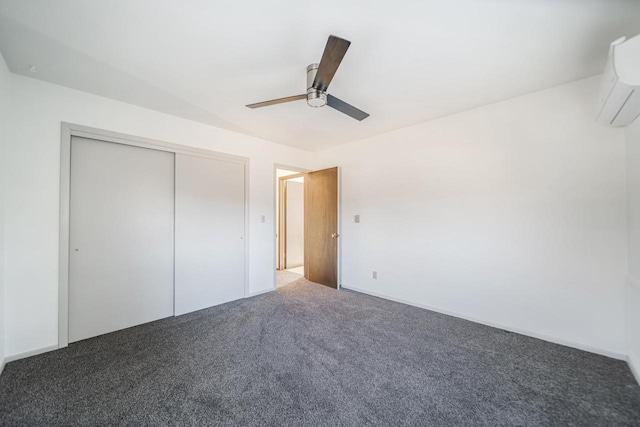 unfurnished bedroom with ceiling fan, a wall mounted AC, dark carpet, and a closet