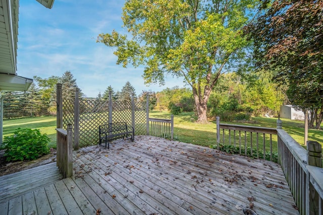 wooden deck with a storage shed and a lawn