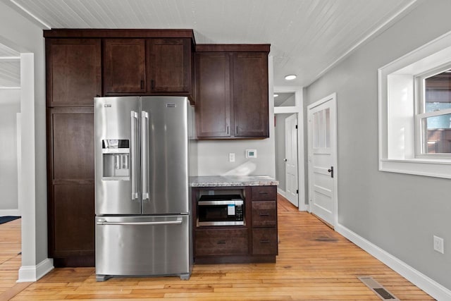 kitchen with dark brown cabinetry, stainless steel appliances, and light hardwood / wood-style floors