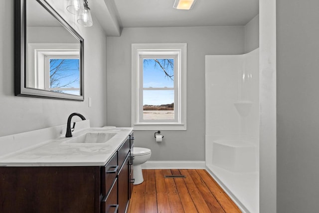 bathroom featuring vanity, wood-type flooring, toilet, and walk in shower