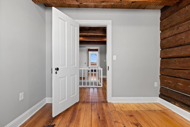 hallway with wood ceiling, hardwood / wood-style floors, and beamed ceiling