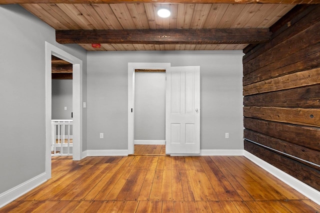 unfurnished bedroom with hardwood / wood-style flooring, beamed ceiling, and wooden ceiling