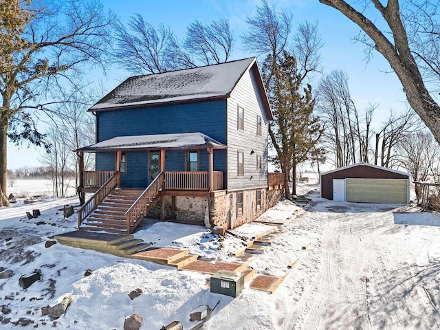 view of front facade featuring an outbuilding, a garage, and a porch