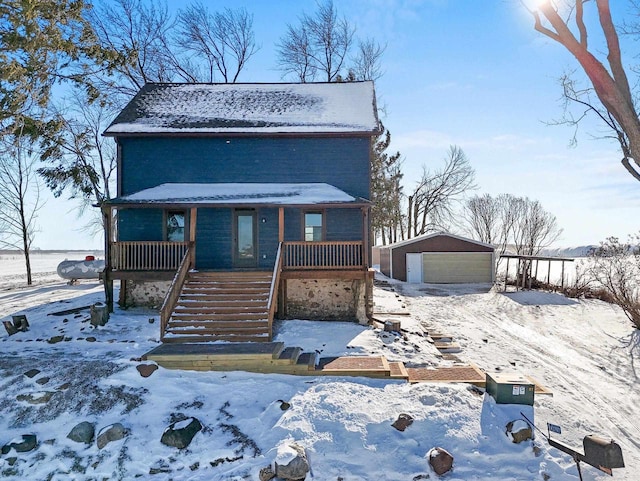 view of front of property featuring a garage, an outbuilding, and covered porch