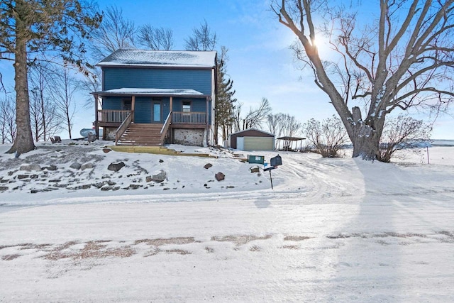 view of front of home with a garage, an outdoor structure, and a porch