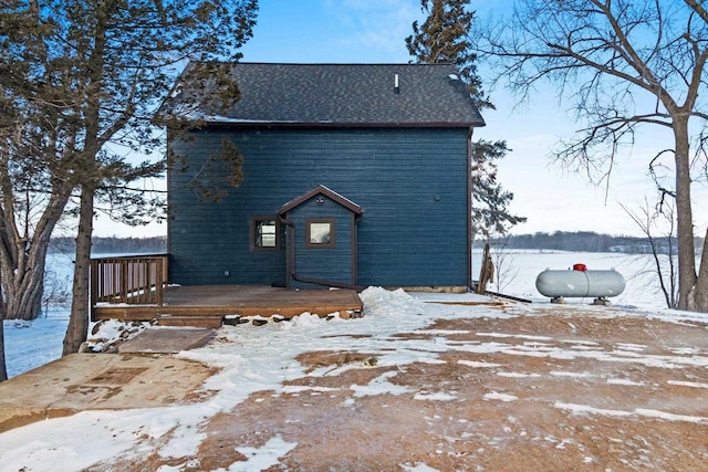 snow covered back of property featuring a deck