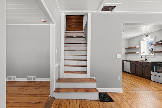 stairway with sink and hardwood / wood-style floors