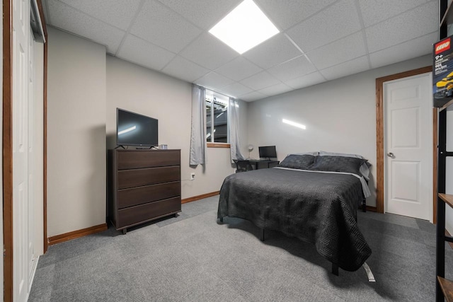 bedroom with a drop ceiling and light carpet