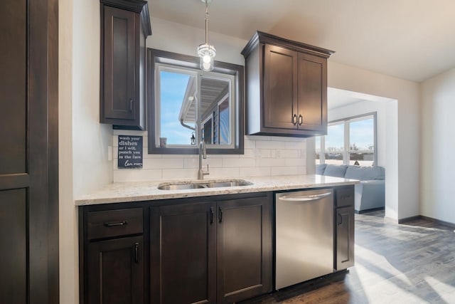 kitchen featuring tasteful backsplash, sink, stainless steel dishwasher, dark brown cabinetry, and dark wood-type flooring