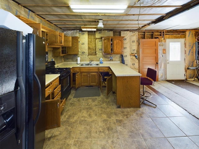 3675 Flanner Ln, Laona, WI 54541 - kitchen with dark tile patterned floors, sink, a kitchen bar, and black appliances