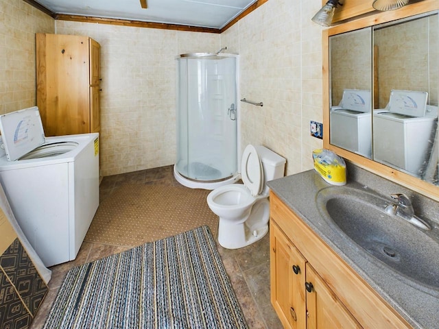 3675 Flanner Ln, Laona, WI 54541 - bathroom featuring a shower with shower door, tile walls, vanity, ornamental molding, and independent washer and dryer