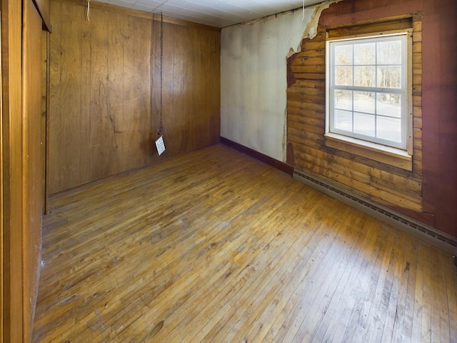 3675 Flanner Ln, Laona, WI 54541 - unfurnished room featuring hardwood / wood-style floors, wood walls, and a baseboard heating unit