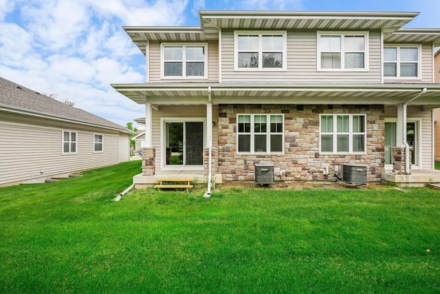 rear view of property with central AC and a yard