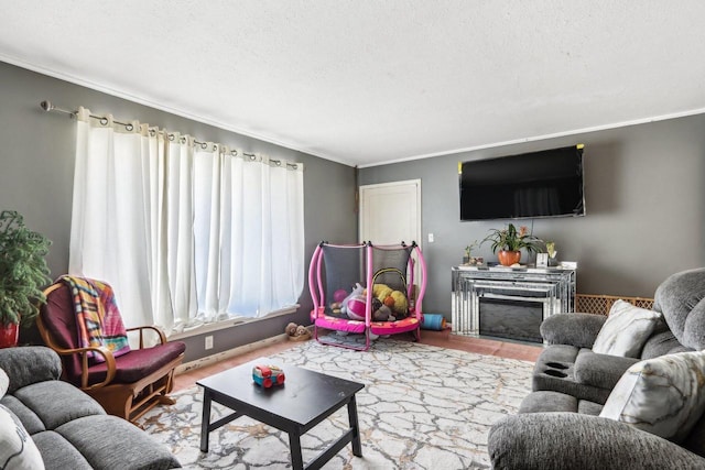 living room featuring crown molding, a textured ceiling, and a fireplace
