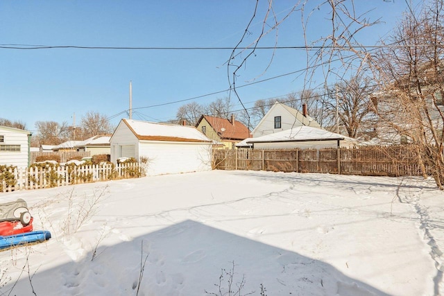 yard layered in snow with fence, an outdoor structure, and a residential view
