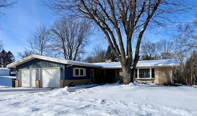 single story home with a garage, board and batten siding, and brick siding