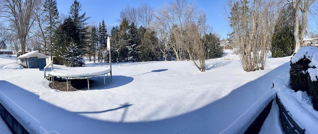 yard covered in snow with a trampoline