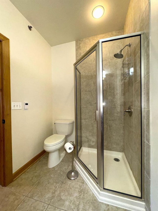 bathroom with an enclosed shower, tile patterned floors, and toilet