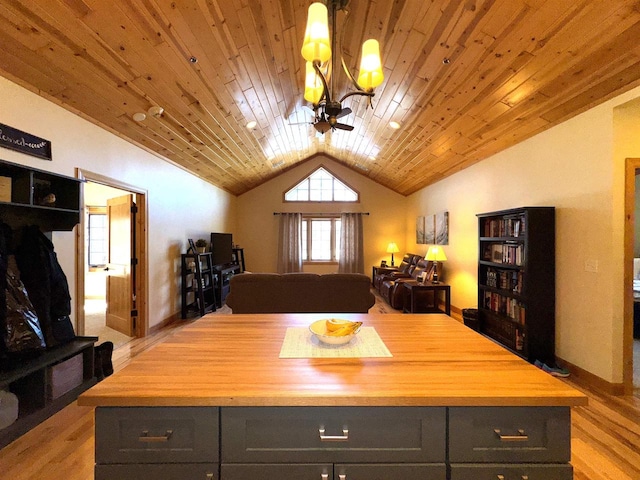 kitchen featuring pendant lighting, vaulted ceiling, butcher block counters, and a kitchen island