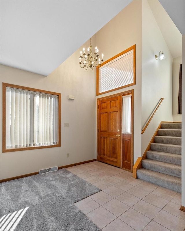 entrance foyer featuring a chandelier, high vaulted ceiling, and light tile patterned floors