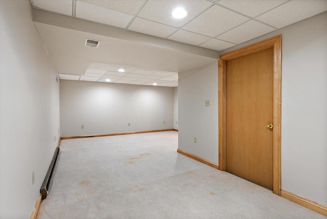 basement with light carpet and a drop ceiling