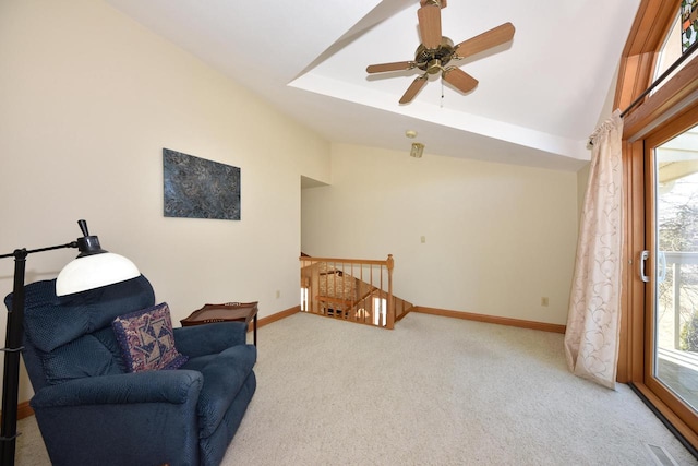 living area with a raised ceiling, vaulted ceiling, and carpet flooring