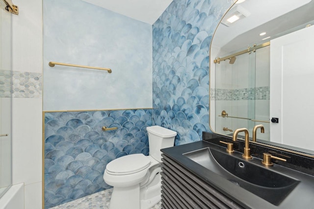 bathroom featuring vanity, a shower with shower door, and toilet