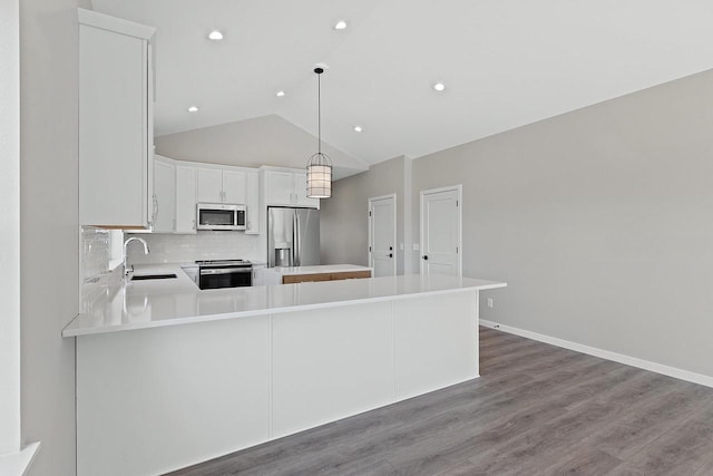 kitchen with sink, hanging light fixtures, kitchen peninsula, stainless steel appliances, and white cabinets