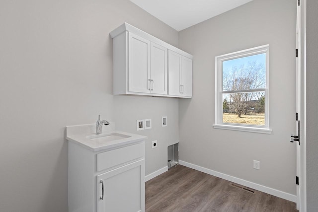 washroom with sink, light hardwood / wood-style flooring, electric dryer hookup, cabinets, and washer hookup