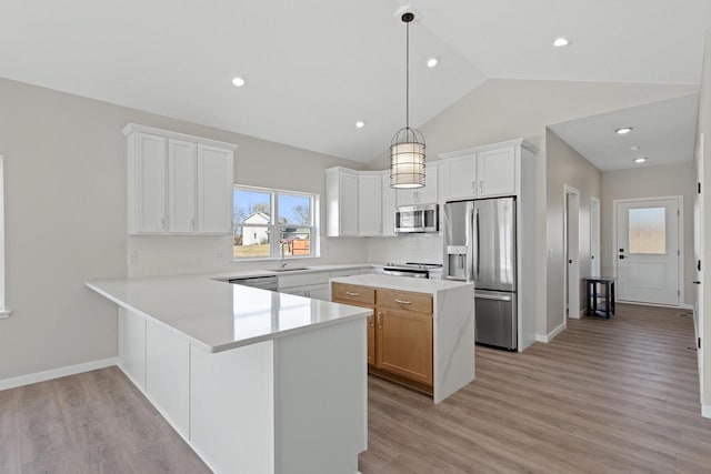 kitchen featuring decorative light fixtures, sink, white cabinets, stainless steel appliances, and light hardwood / wood-style flooring