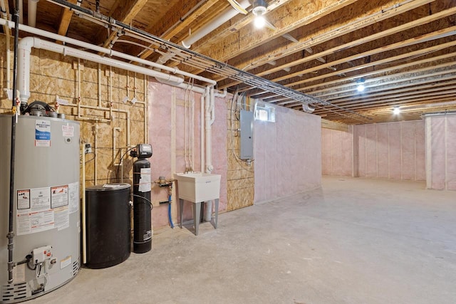 basement featuring electric panel, sink, and water heater