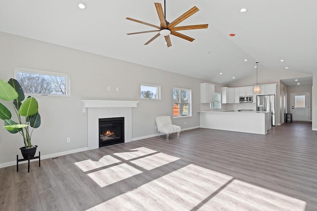 unfurnished living room featuring high vaulted ceiling and light hardwood / wood-style floors