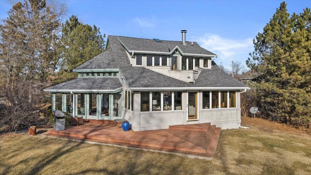 rear view of house with a wooden deck, a yard, and a sunroom