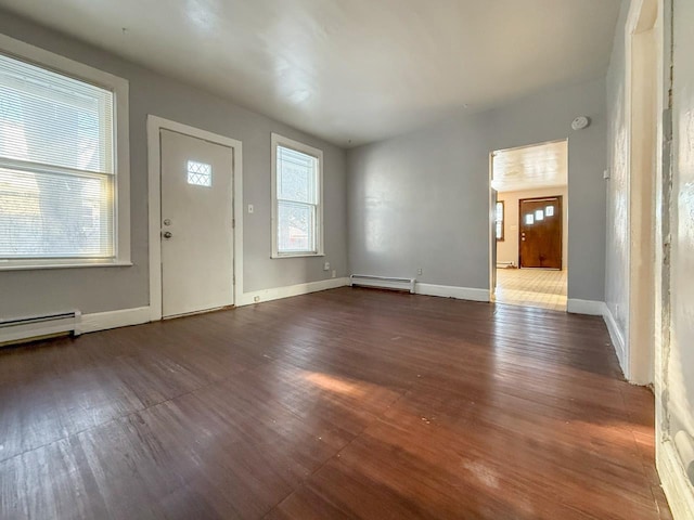 foyer with dark wood-type flooring and a baseboard heating unit