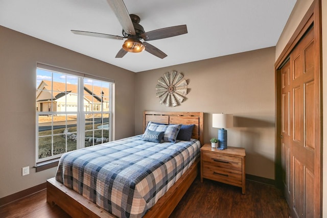 bedroom with dark wood-type flooring, ceiling fan, and a closet
