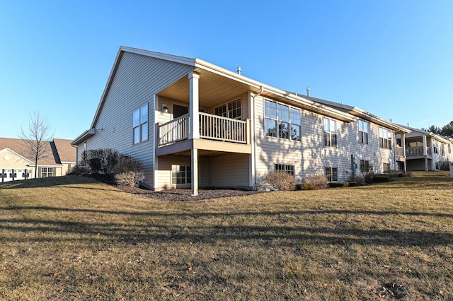 back of property with a yard and a balcony