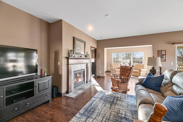 living room with dark hardwood / wood-style flooring and a tile fireplace