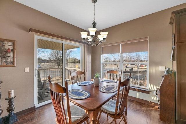 dining area with dark hardwood / wood-style flooring and a notable chandelier