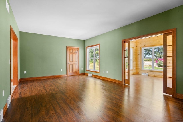 spare room with plenty of natural light and dark hardwood / wood-style floors