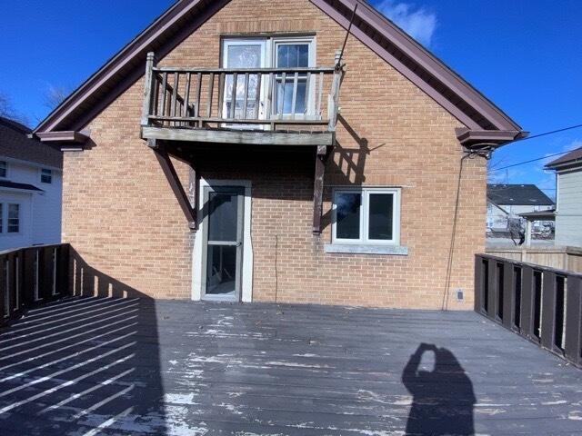 back of property with a balcony and a deck