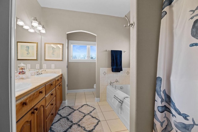 bathroom with tile patterned flooring, vanity, toilet, and a tub to relax in