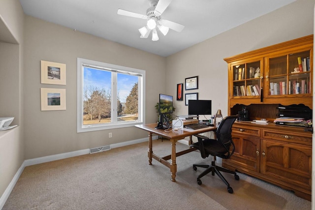 carpeted home office featuring ceiling fan