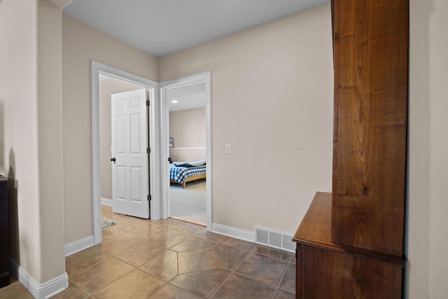 hall with tile patterned floors