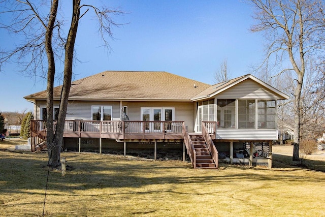 back of property featuring a yard, a deck, and a sunroom